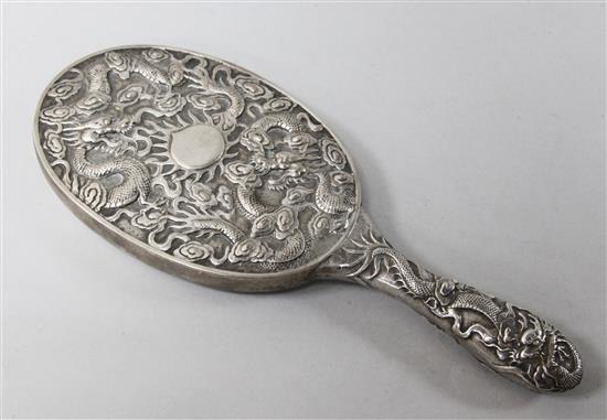 A late 19th/early 20th century Chinese Export silver hand mirror by Ning Zhao Ji for Taylor & Co, decorated with dragons, 26.2cm.